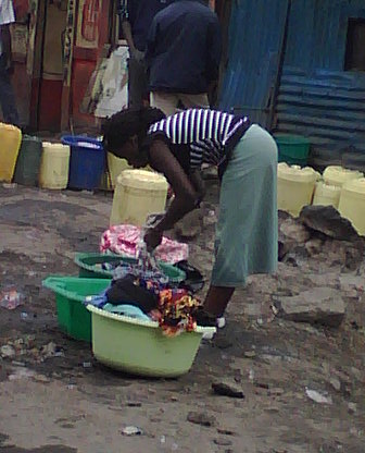 A woman washing clothes near a water point in Mathare